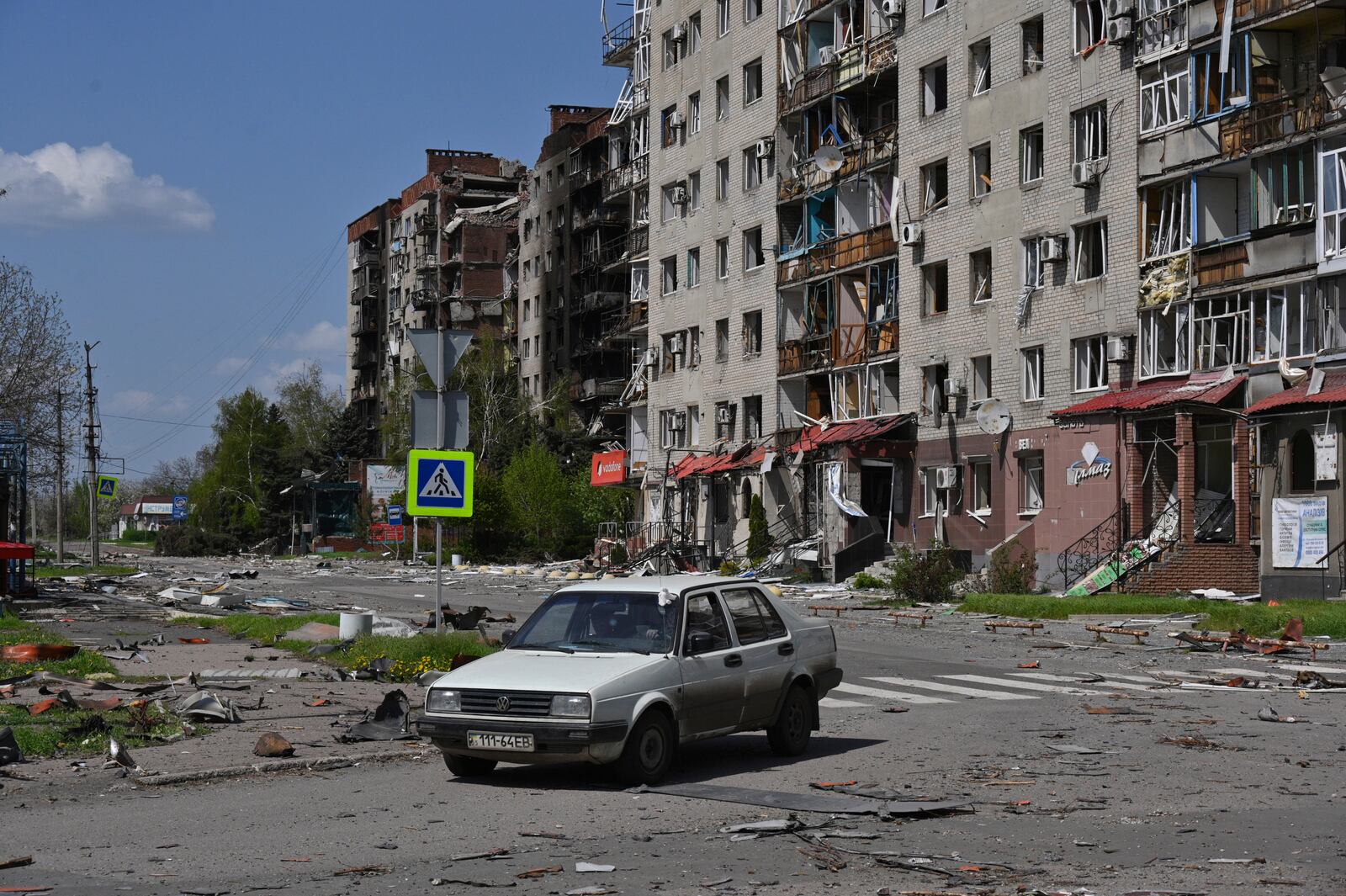 An abandoned car stands against the background of damaged buildings in central Pokrovsk, the site of the heaviest battles with the Russian troops in the Donetsk region, Ukraine, Wednesday, April 23, 2025. (AP Photo/Michael Shtekel)
