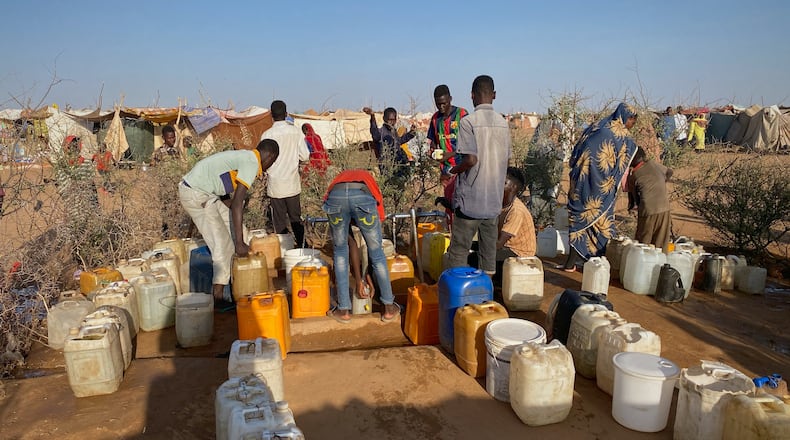Sudanese men who fled el-Fasher city, after Sudan's paramilitary forces killed hundreds of people in the western Darfur region, collect water at a camp in Tawila, Sudan, Saturday, Nov. 1, 2025. (AP Photo/Mohammed Bakry)