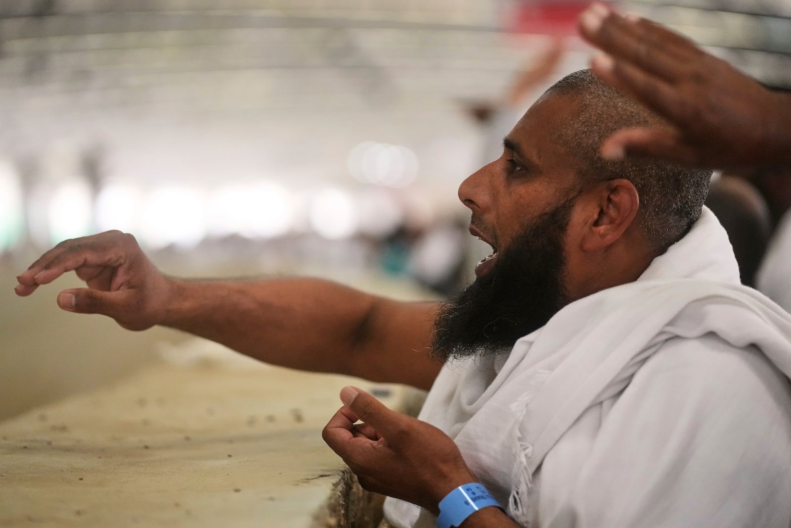 A Muslim pilgrim casts stones at pillars in the symbolic stoning of the devil, the last rite of the annual Hajj, in Mina near the holy city of Mecca, Saudi Arabia, Friday, June 6, 2025. (AP Photo/Amr Nabil)