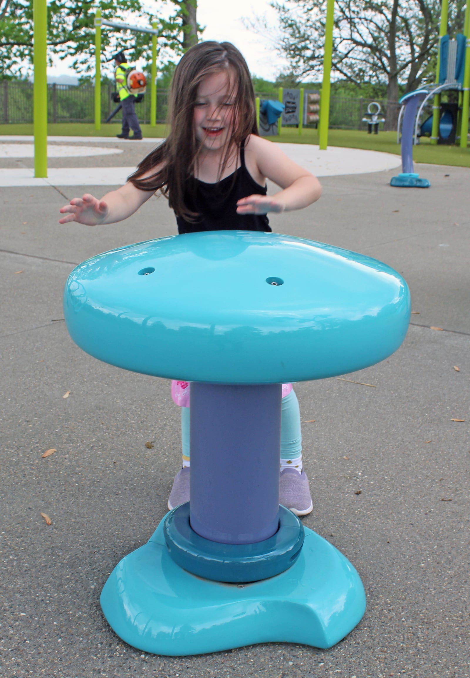 Hannah Martin, 5, was spinning the WhirlPad at Fairfield's splash pad during a recent visit before the water was turned on. It is one of 15 play features. CREDIT/SUE KIESEWETTER