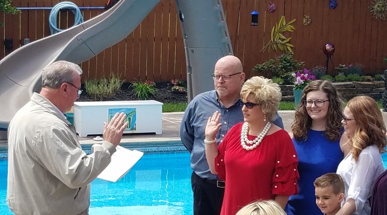 Carlisle Mayor Randy Winkler, left, administers the oath of office to Kim Bilbrey as the village’s newest council member. Bilbrey was appointed during a special session Friday and was sworn-in with her family present at her home. She succeeds former councilman Brad McIntosh who resigned last month. CONTRIBUTED PHOTO