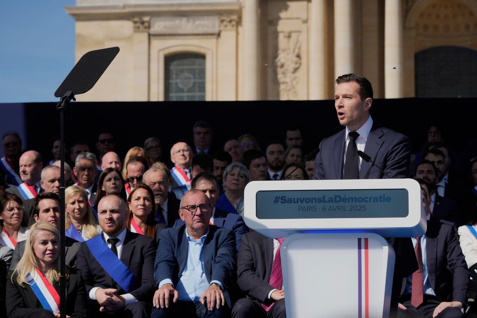 The leader of France's National Rally (RN) Jordan Bardella delivers his speech during the French far-right party national rally near the parliament in support of Marine Le Pen in Paris, Sunday, April 6, 2025. (AP Photo/Michel Euler)
