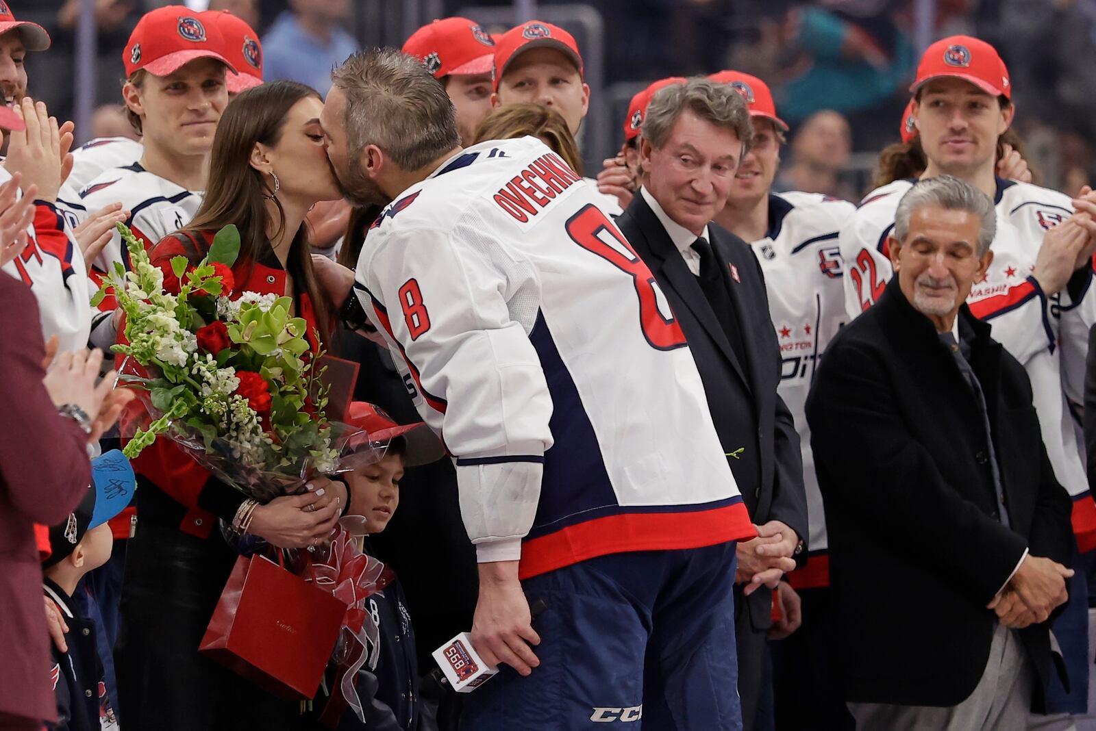Washington Capitals left wing Alex Ovechkin (8) kisses his wife Nastya during a ceremony after he scored his 895th career goal during the second period of an NHL hockey game against New York Islanders in Elmont, N.Y., Sunday, April 6, 2025. (AP Photo/Adam Hunger)