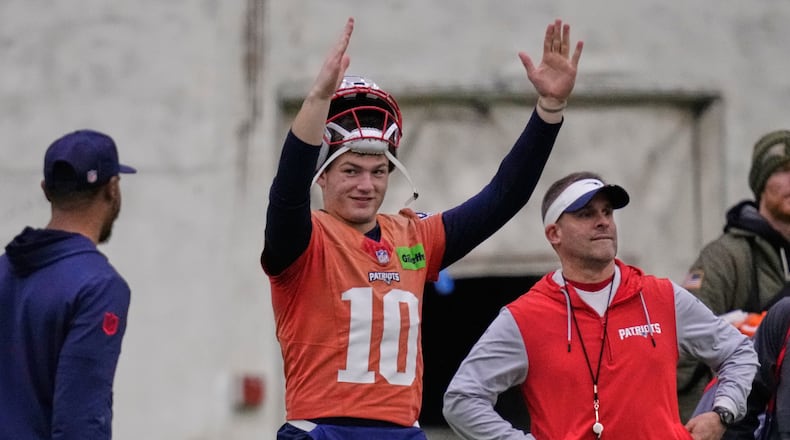 New England Patriots quarterback Drake Maye, left, signals after a field goal while standing with offensive coordinator Josh McDaniels during an NFL football availability, Thursday, Jan. 29, 2026, in Foxborough, Mass. (AP Photo/Charles Krupa)