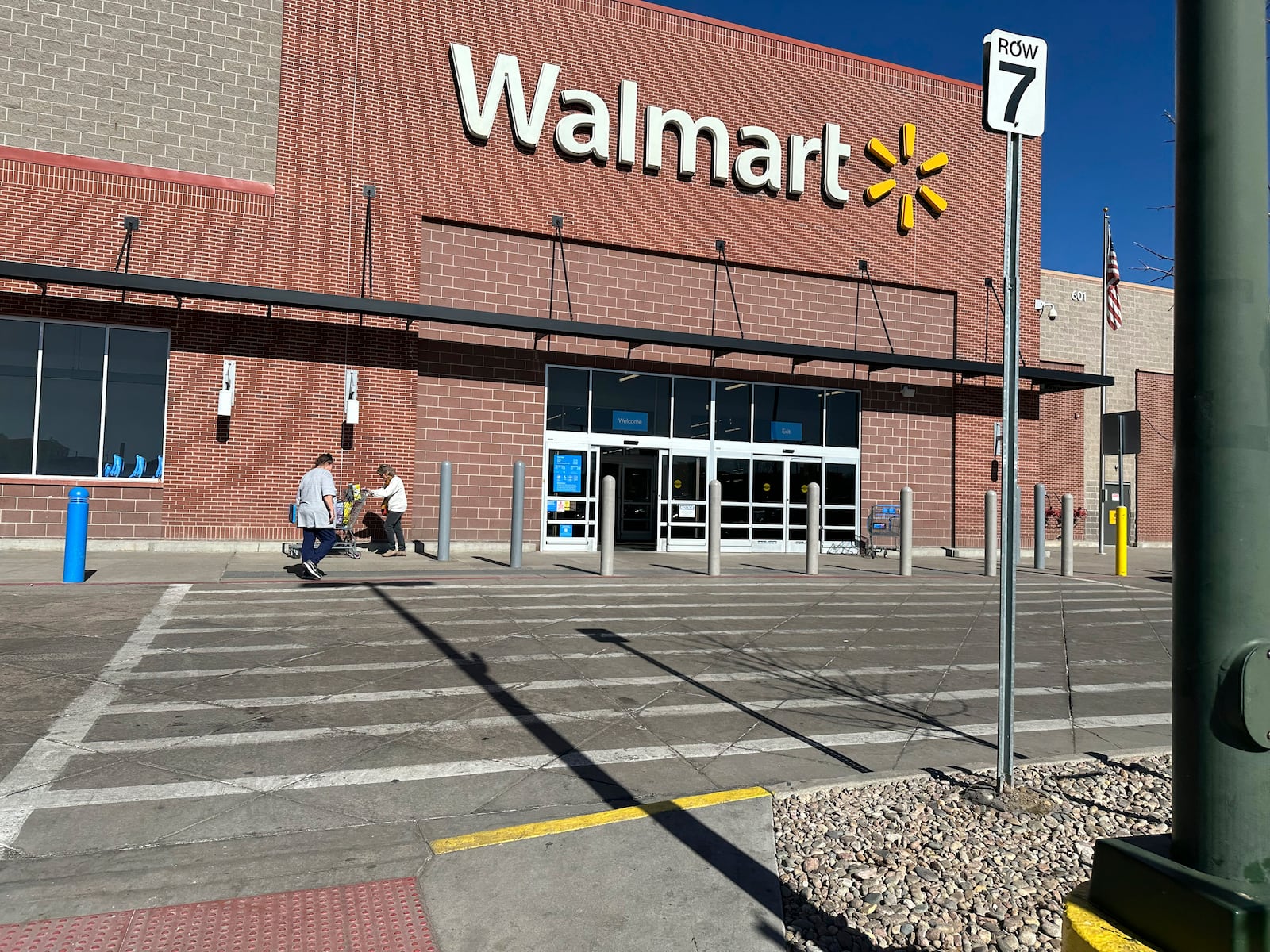 FILE -Shoppers outside a Walmart store, Feb. 7, 2025, in Englewood, Colo. (AP Photo/David Zalubowski), File)