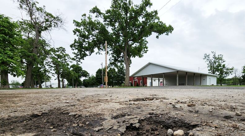 Numerous vehicles driving through during Covid-19 vaccine clinics caused some sections of asphalt to be damaged at Butler County Fairgrounds in Hamilton. Covid-19 relief funds could be used to pave areas of the fairgrounds. NICK GRAHAM/STAFF