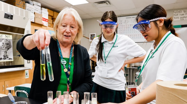 Badin High School chemistry teacher Teresa Heinrich helps Molly Black, middle, and Gracie Luong, right, with a lab project Friday, May 12, 2023 in Hamilton. Heinrich is Badin's most veteran teacher and is finishing her 43rd year of teaching at Badin. NICK GRAHAM/STAFF
