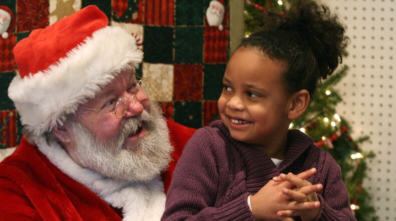 Olivia Albrecht, 6, laughs as she tells Santa what she wants in 2009 at the Santa House in Hamilton. The Santa House will open for the 2018 Christmas season on Dec. 1.
