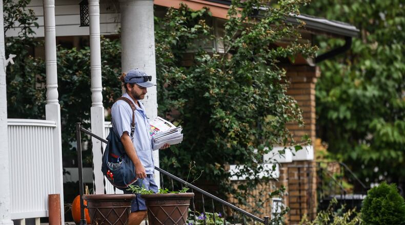 A mail carrier delivers mail on Watervliet Ave. Monday Oct. 4, 2021. For delivery by Dec. 25 within the lower 48 states, the U.S. Postal Service advises people using its ground service to send items by Dec. 15. Those using First-Class Mail and Priority Mail have until Dec. 17 and 18, respectively — one day earlier than last year. The recommended shipping date for Priority Mail Express, Dec. 23, hasn’t changed. JIM NOELKER/STAFF