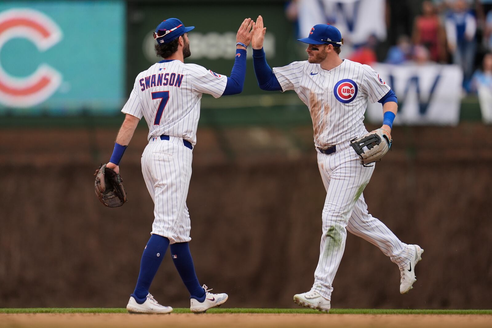 Chicago Cubs' Dansby Swanson (7) and Ian Happ, right, celebrate after their win over the Arizona Diamondbacks in a baseball game Friday, April 18, 2025, in Chicago. (AP Photo/Erin Hooley)