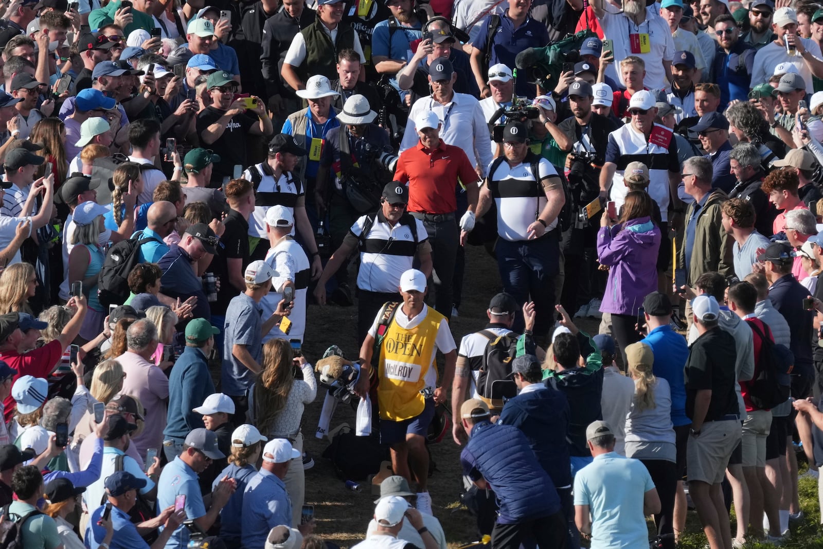 Rory McIlroy of Northern Ireland goes to his ball on the 17th which landed win the crowd during the third round of the British Open golf championship at the Royal Portrush Golf Club, Northern Ireland, Saturday, July 19, 2025. (AP Photo/Jon Super)