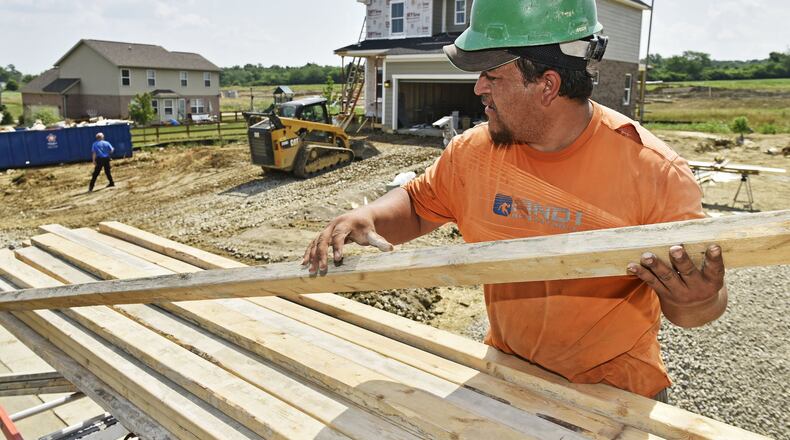 Jose Hernandez with JK Excavating unloads materials at a home being constructed Monday, June 18, in Monroe. Temperatures in the low- to mid-90s were widespread Monday, with heat indexes more than 100 degrees. NICK GRAHAM/STAFF