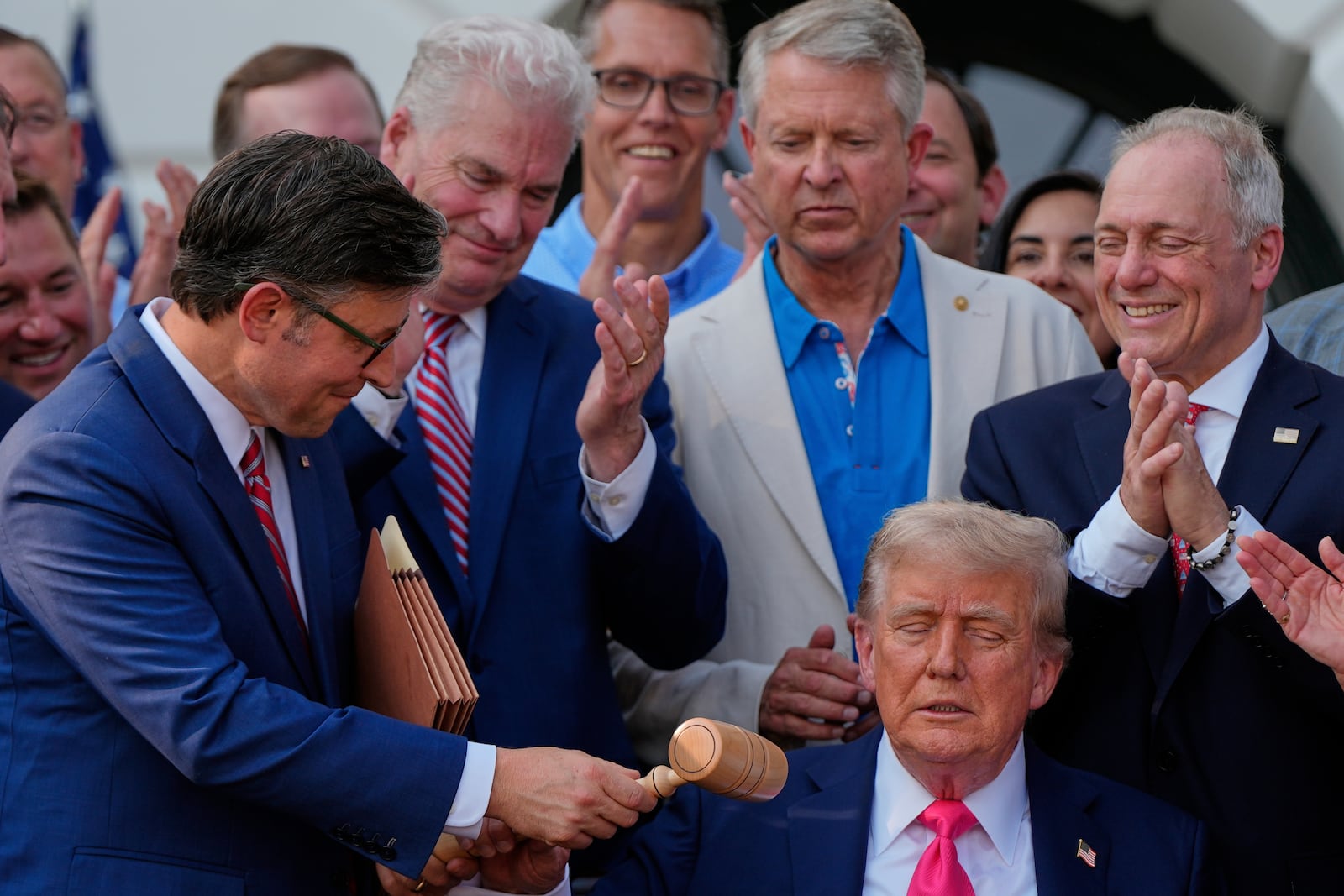 House Speaker Mike Johnson of La., hands President Donald Trump a gavel after he signed his signature bill of tax breaks and spending cuts at the White House, Friday, July 4, 2025, in Washington, surrounded by members of Congress. (AP Photo/Julia Demaree Nikhinson)