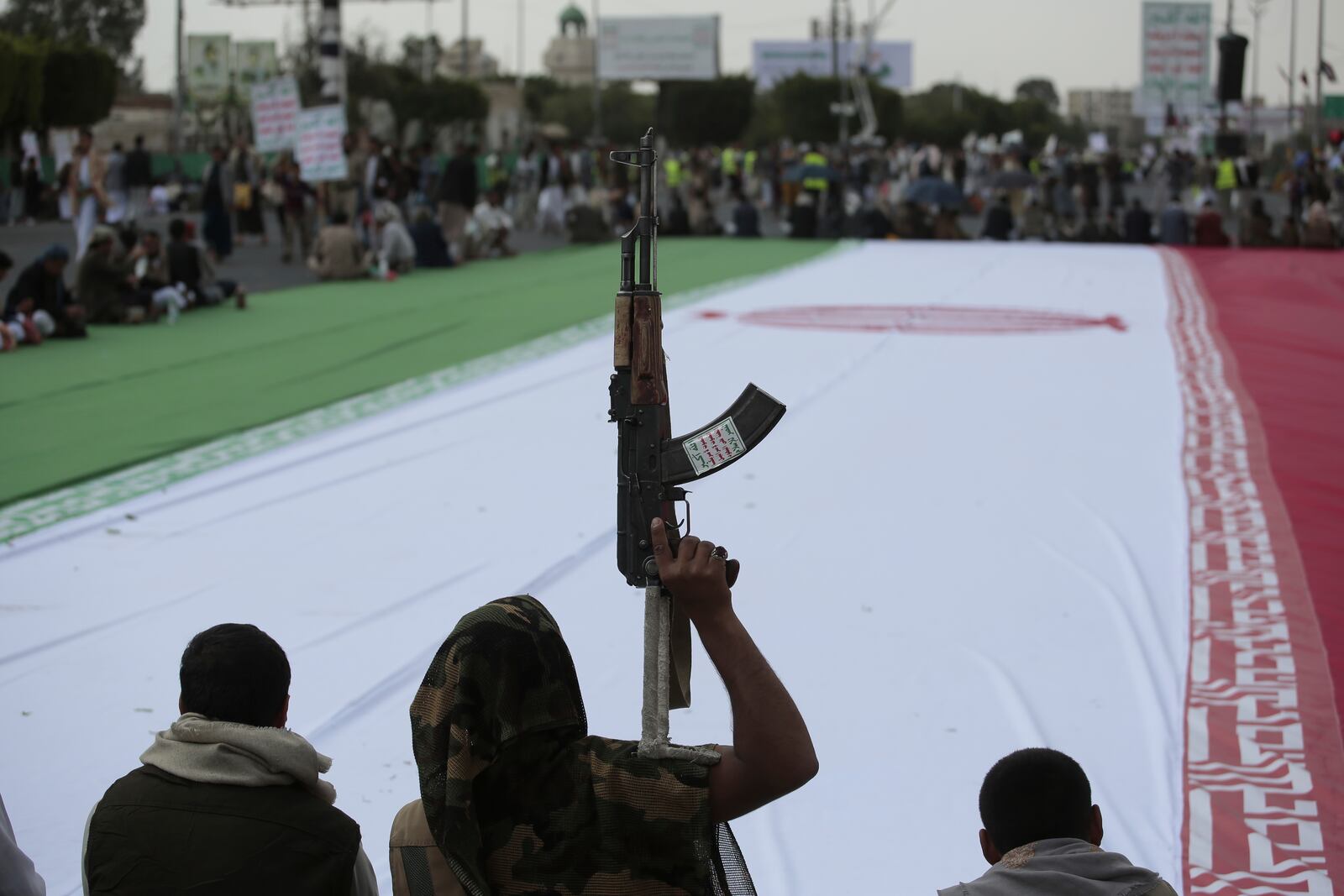 Houthi supporters surround a giant Iranian flag during an anti-U.S. and anti-Israel weekly rally in Sanaa, Yemen, Friday, June 20, 2025. (AP Photo/Osamah Abdulrahman)