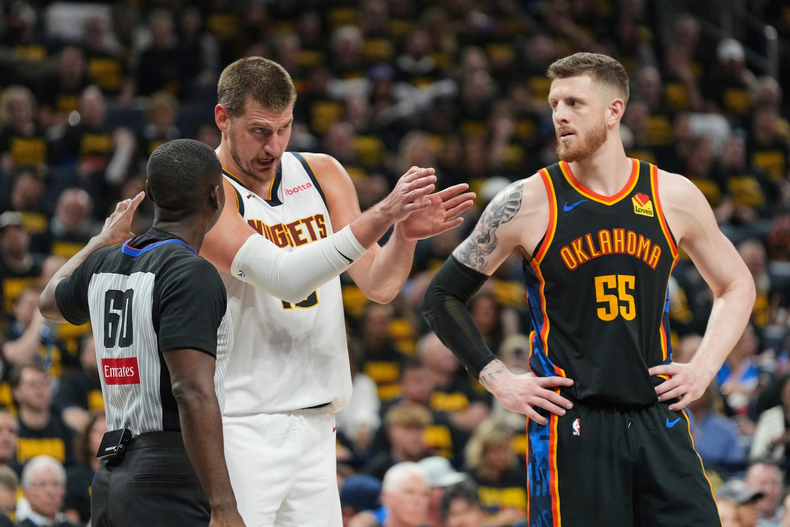 Denver Nuggets center Nikola Jokic, center, talks with referee James Williams (60) as Oklahoma City Thunder's Isaiah Hartenstein (55) looks on in the second half of Game 2 in the conference semifinals of the NBA basketball playoffs, Wednesday, May 7, 2025, in Oklahoma City. (AP Photo/Kyle Phillips)