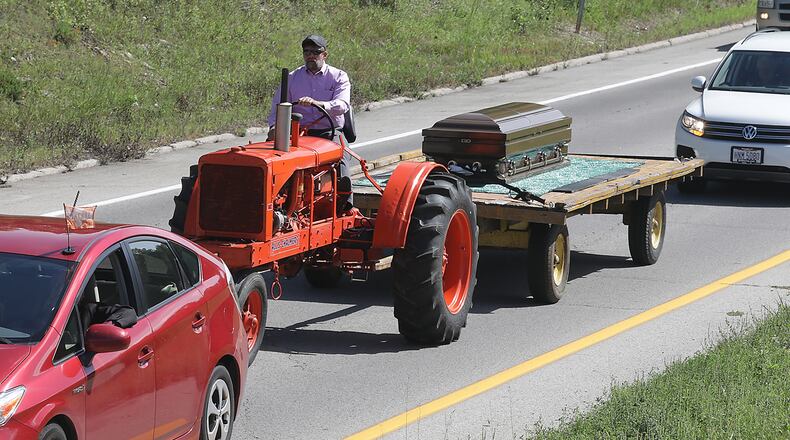 The body of Darrell Foster, a lifelong Clark County farmer, was transported from the Jackson, Lytle and Lewis Life Celebration Center to the cemetery in Lawrenceville Friday on a wagon being pulled by the antique Allis-Chalmer tractor that he had restored. Foster died last Saturday. BILL LACKEY/STAFF