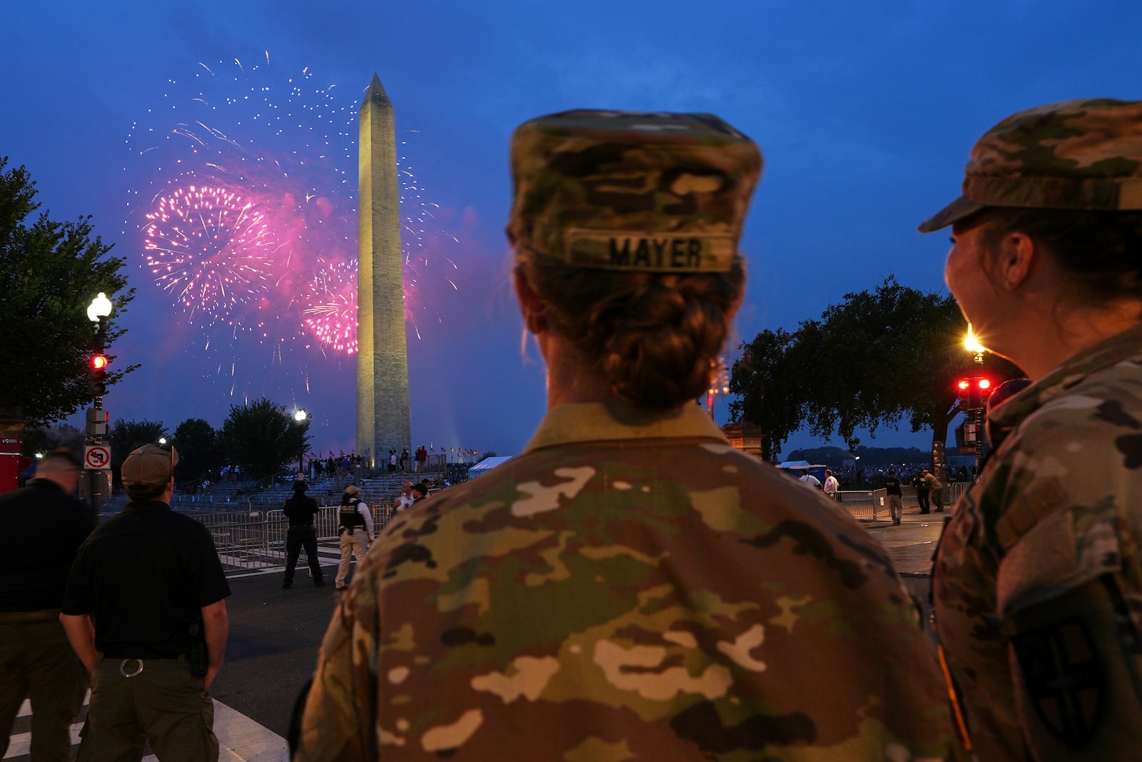 U.S. Army 2nd Lt. Hayle Mayer, left, and Corporal Addison Merrell, watch fireworks at the Washington Monument while attending a military parade commemorating the Army's 250th anniversary and coinciding with President Donald Trump's 79th birthday, Saturday, June 14, 2025, in Washington. (AP Photo/Jacquelyn Martin)