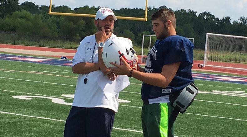 Talawanda coach J.D. Vonderheide talks to quarterback Adam Crank during Monday’s practice at the school. RICK CASSANO/STAFF