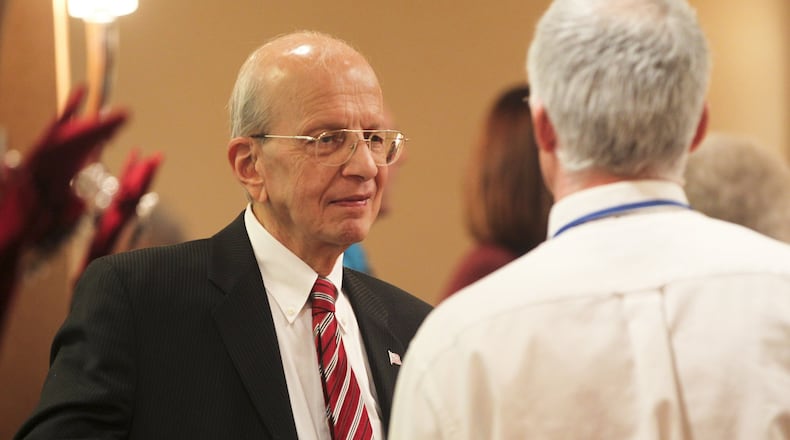 George Jonson talks with well-wishers during a reception in December 2013 for departing Hamilton Board of Education members at the Courtyard by Marriott. Jonson served on the board for 32 years. Anna Harvey also departed from the board. GREG LYNCH/FILE