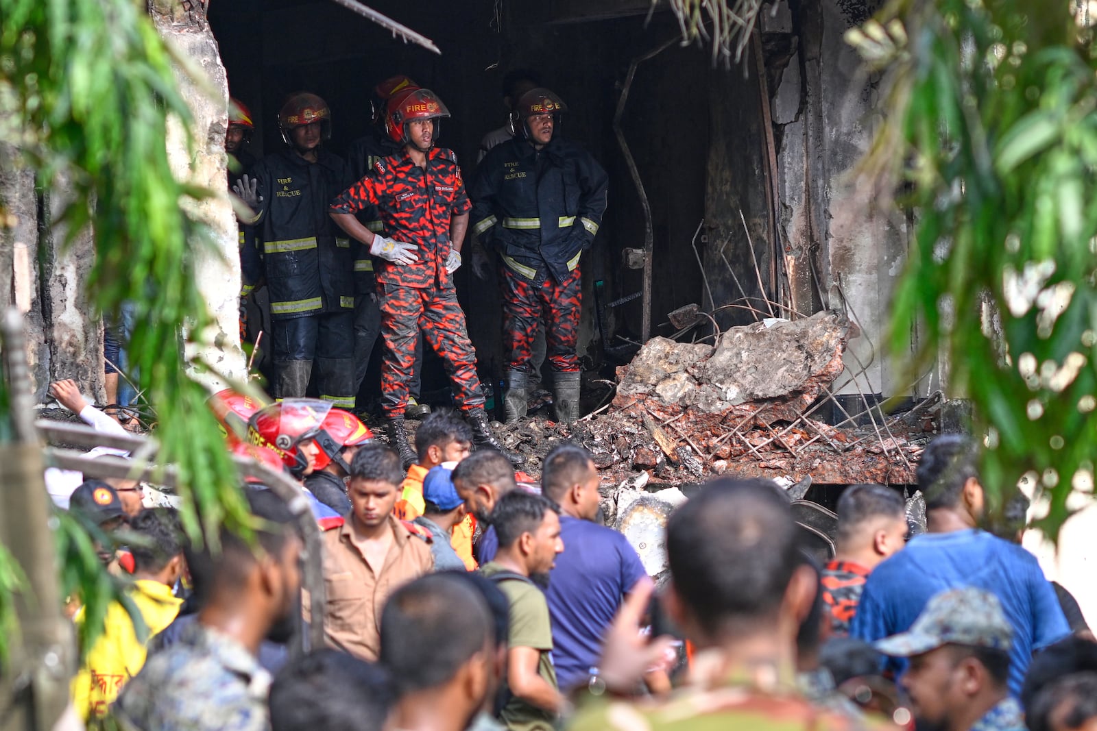 Firemen look for the survivors after a Bangladesh Air Force training aircraft that crashed onto a school campus shortly after takeoff in Dhaka, Bangladesh, Monday, July 21, 2025. (AP Photo/Mahmud Hossain Opu)