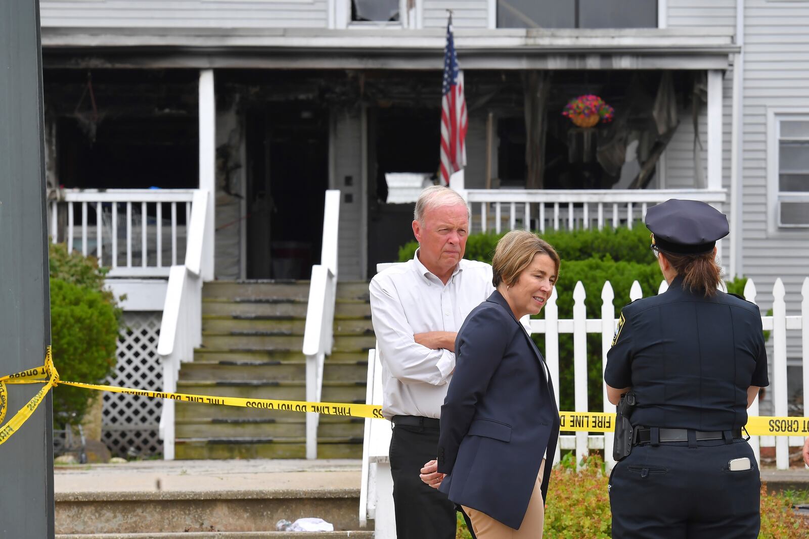 Massachusetts Gov. Maura Healey, center, and Fall River Mayor Paul Coogan, left, speak with a member of law enforcement, right, near the Gabriel House assisted living facility, Monday, July 14, 2025, following a fire that started late Sunday, in Fall River, Mass. (AP Photo/Steven Senne)