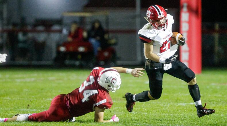 Madison’s Gabe Higgs carries the football defended by Carlisle’s Jayden Sweeney during their game Friday night, Oct. 11, 2019 at Laughlin Field in Carlisle. Madison won 26-16. NICK GRAHAM/STAFF