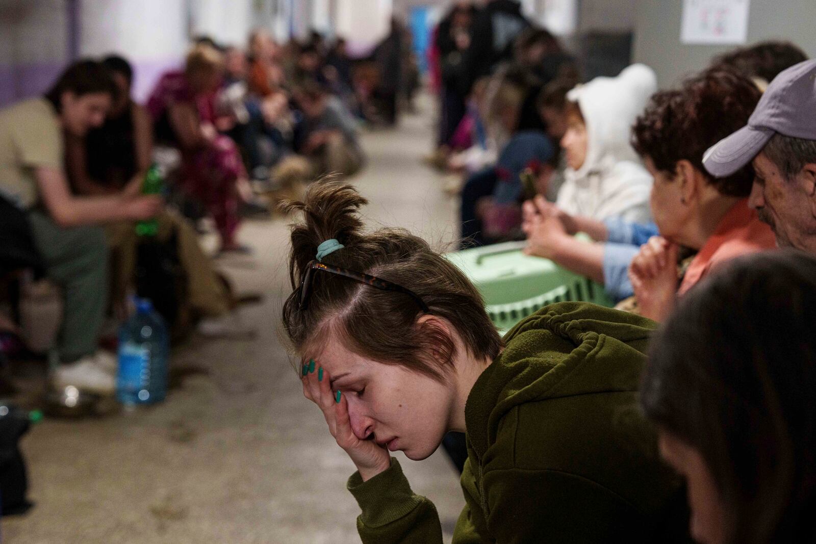 A woman sits in a school basement being used as a shelter after a Russian airstrike on a residential neighborhood in Kyiv, Ukraine, on Thursday, April 24, 2025. (AP Photo/Evgeniy Maloletka)