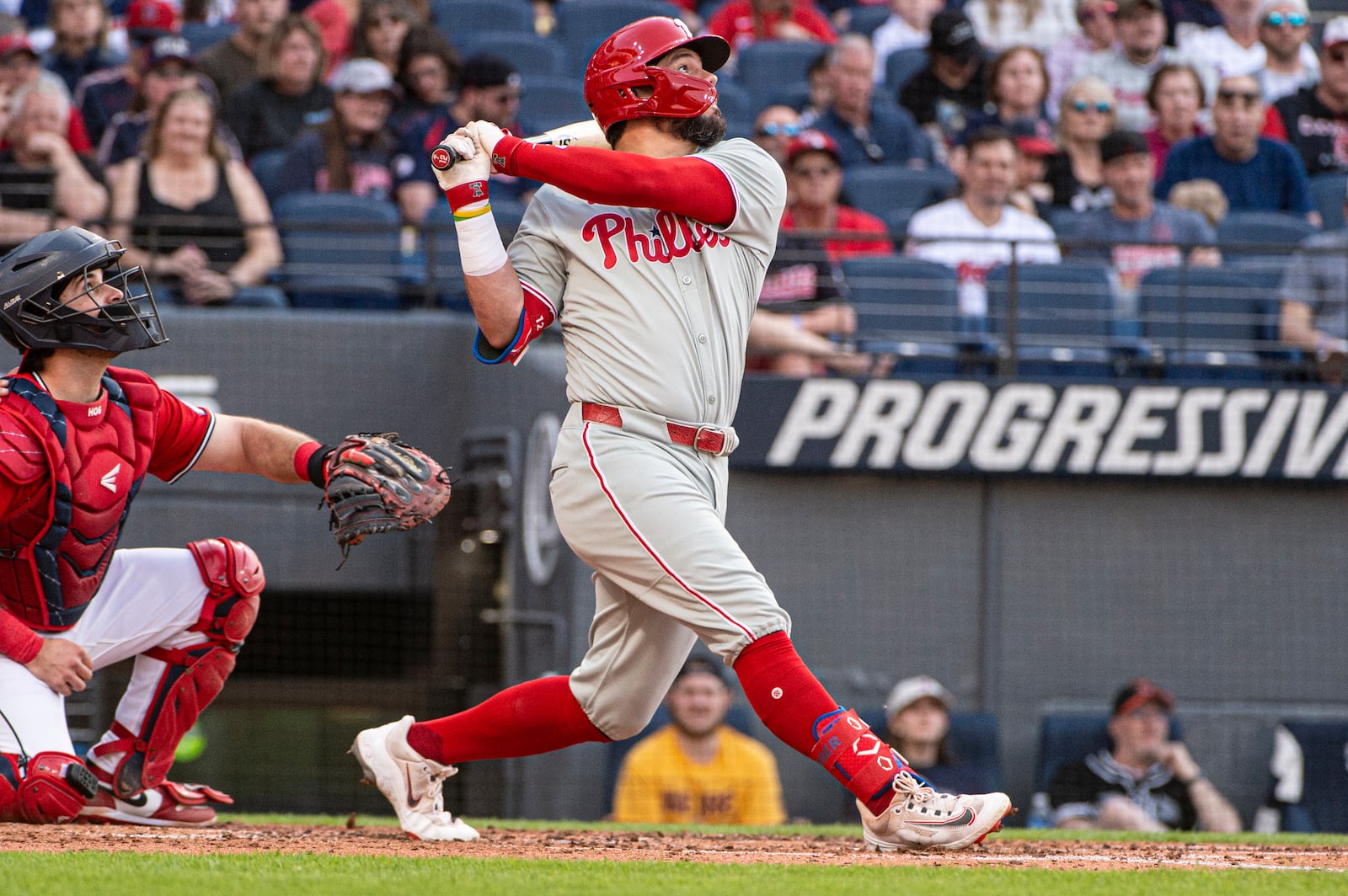 Philadelphia Phillies' Kyle Schwarber, right, watches his RBI single off Cleveland Guardians starting pitcher Tanner Bibee as Austin Hedges, left, watches during the fourth inning of a baseball game Saturday, May 10, 2025, in Cleveland. (AP Photo/Phil Long)
