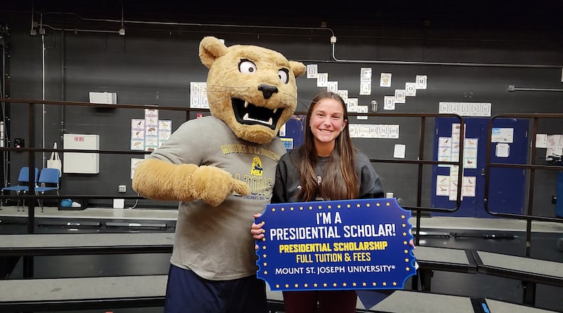 Monroe High School senior Lindsey Bevak suspected something was up. The star soccer player and top academic performer was recently called out of class by Monroe Principal Tom Prohaska to stop by his office one afternoon but with no details as to why. He led her to the auditorium and waiting for her was crowd, including officials from a local college and the school's mascot to surprise her with a full scholarship. Afterward, the mascot posed with Bevak. (Provided Photo\Journal-News)