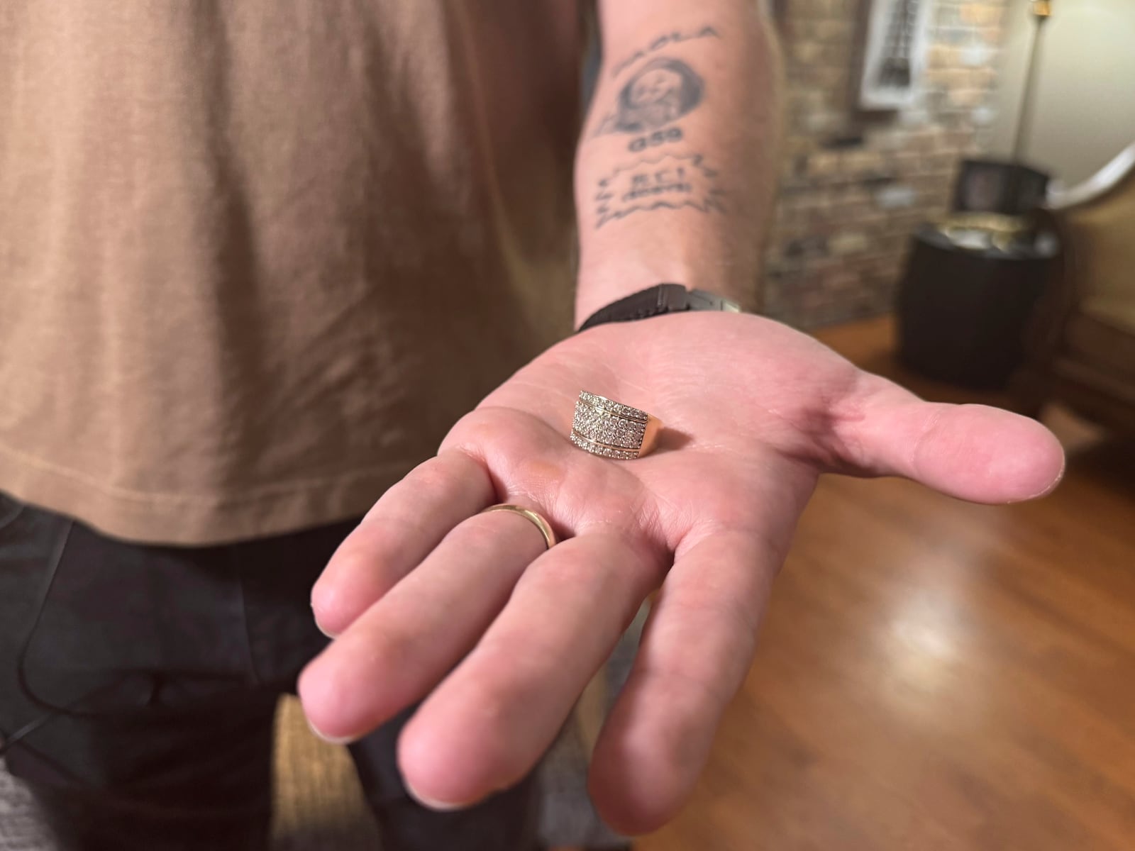 U.S. Marine Corps veteran Adrian Clouatre holds his wife Paola's wedding ring at his house in Baton Rouge, La. on Tuesday, June 17, 2025, which she gave to him after being arrested by ICE officers in May. (AP Photo/Jack Brook)
