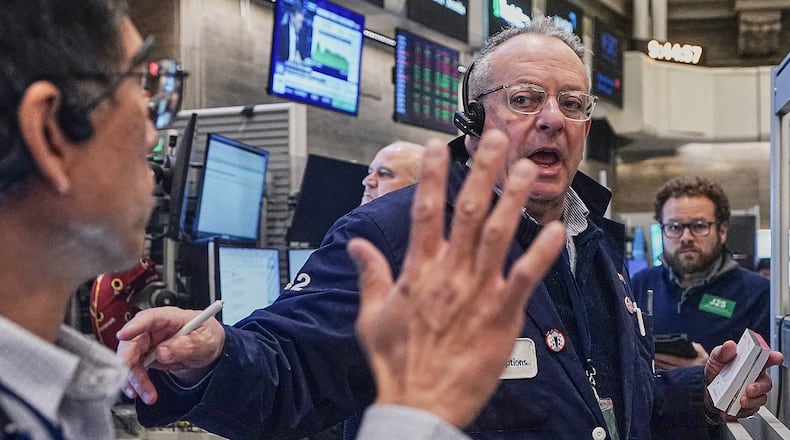 Options trader Phil Fracassini, center, works on the floor of the New York Stock Exchange, Monday, Feb. 2, 2026. (AP Photo/Richard Drew)