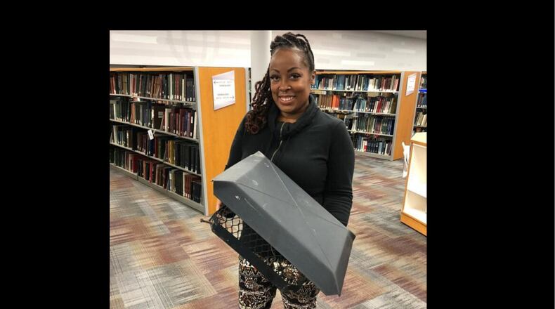 Dayton area resident shared stories of survival as part of the Dayton Strong Storytelling Sessions recorded at the Dayton Metro Library. Billi Ewing is pictured. Ewing and her family survived the Memorial Day tornadoes in Trotwood and were helped by others. She holds a piece of her home.