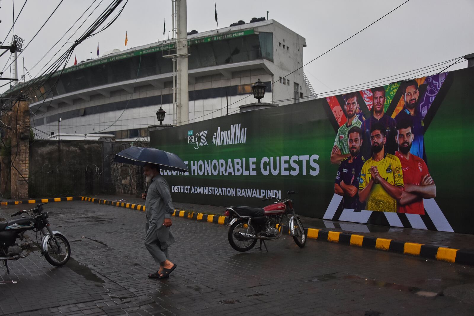 A Pakistani walks past the Pindi Cricket Stadium, where a suspected Indian drones crashed in parking area, in Rawalpindi, Pakistan, Thursday, May 8, 2025. (AP Photo/W.K. Youszai)