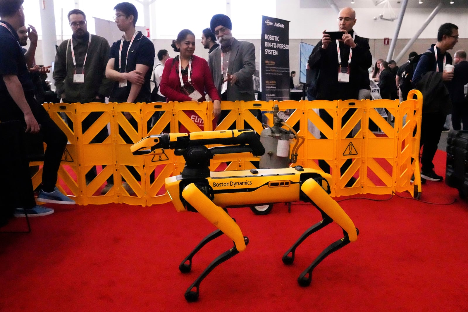 Convention guests watch as a Boston Dynamics robot is demontrated at the Robotics Summit & Expo, Wednesday, April 30, 2025, in Boston. (AP Photo/Charles Krupa)