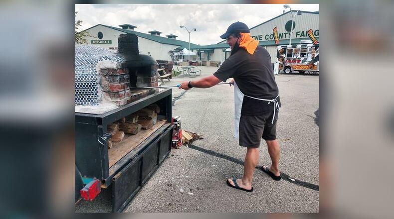 Michael Manning, 45, owner of Pizza Cicerone in Fairfield, prepares pizza in his wood-oven during a food festival at the Greene County Fairgrounds. Pizza Cicerone recently opened inside Swine City Brewery on Industry Drive. SUBMITTED PHOTO