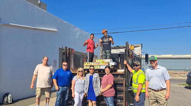 The city of Hamilton’s annual Fill a Dump Truck campaign received more than 2,600 pounds of food for Serve City’s pantry. Pictures are Hamilton and Serve City officials. PROVIDED