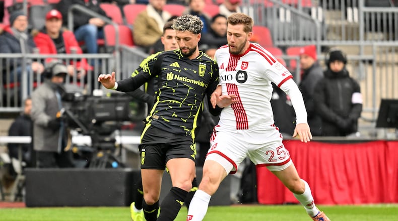 Columbus Crew forward Wessam Abou Ali, left, battles for the ball with Toronto FC defender Walker Zimmerman during the first half of an MLS soccer game in Toronto, Saturday, March 21, 2026. (Jon Blacker/The Canadian Press via AP)