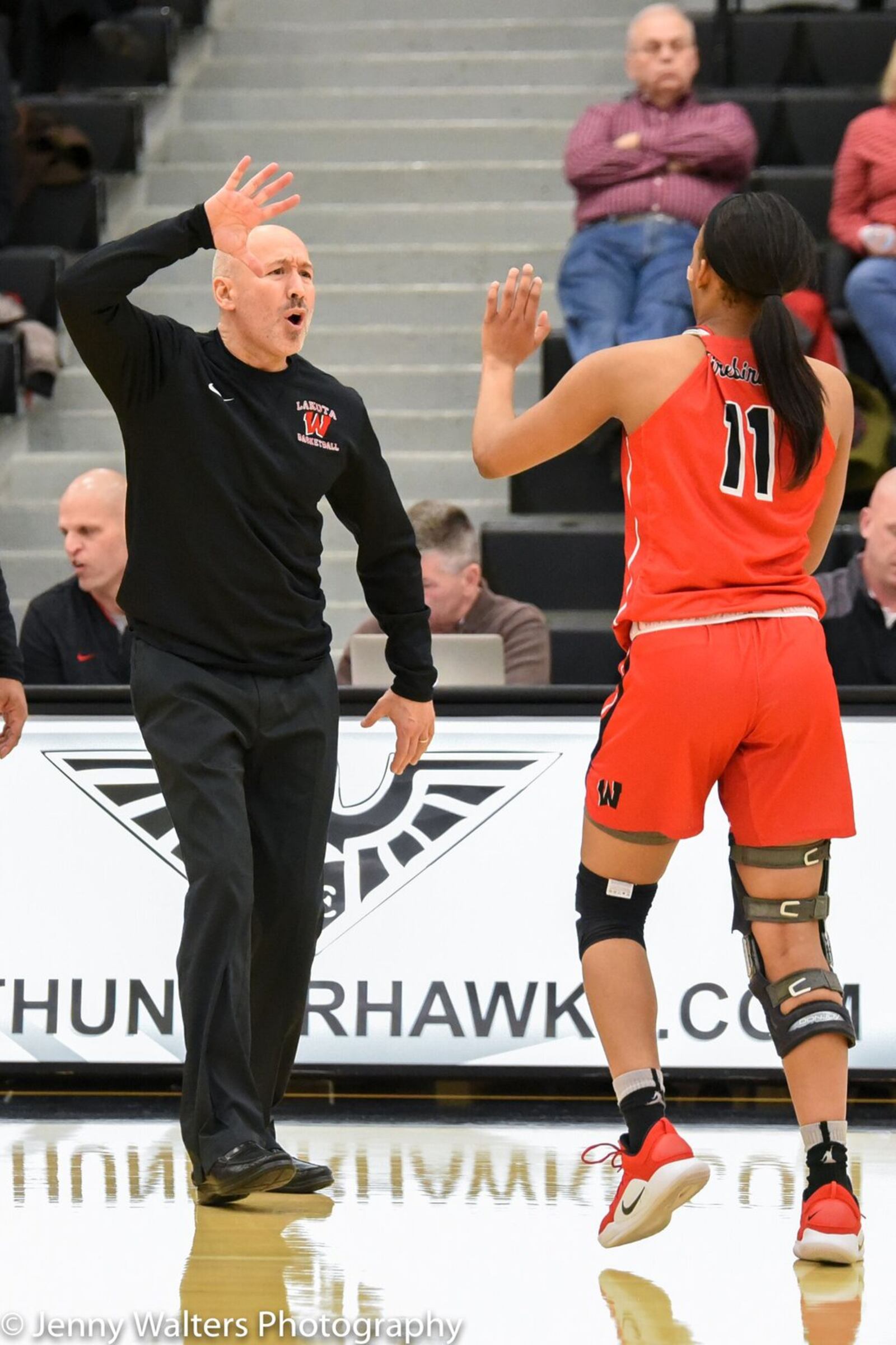 Lakota West coach Andy Fishman greets Dominique Camp (11) as she comes off the floor Monday night during a Division I district basketball semifinal against Sycamore at Lakota East. West won 50-35. PHOTO COURTESY OF JENNY WALTERS PHOTOGRAPHY