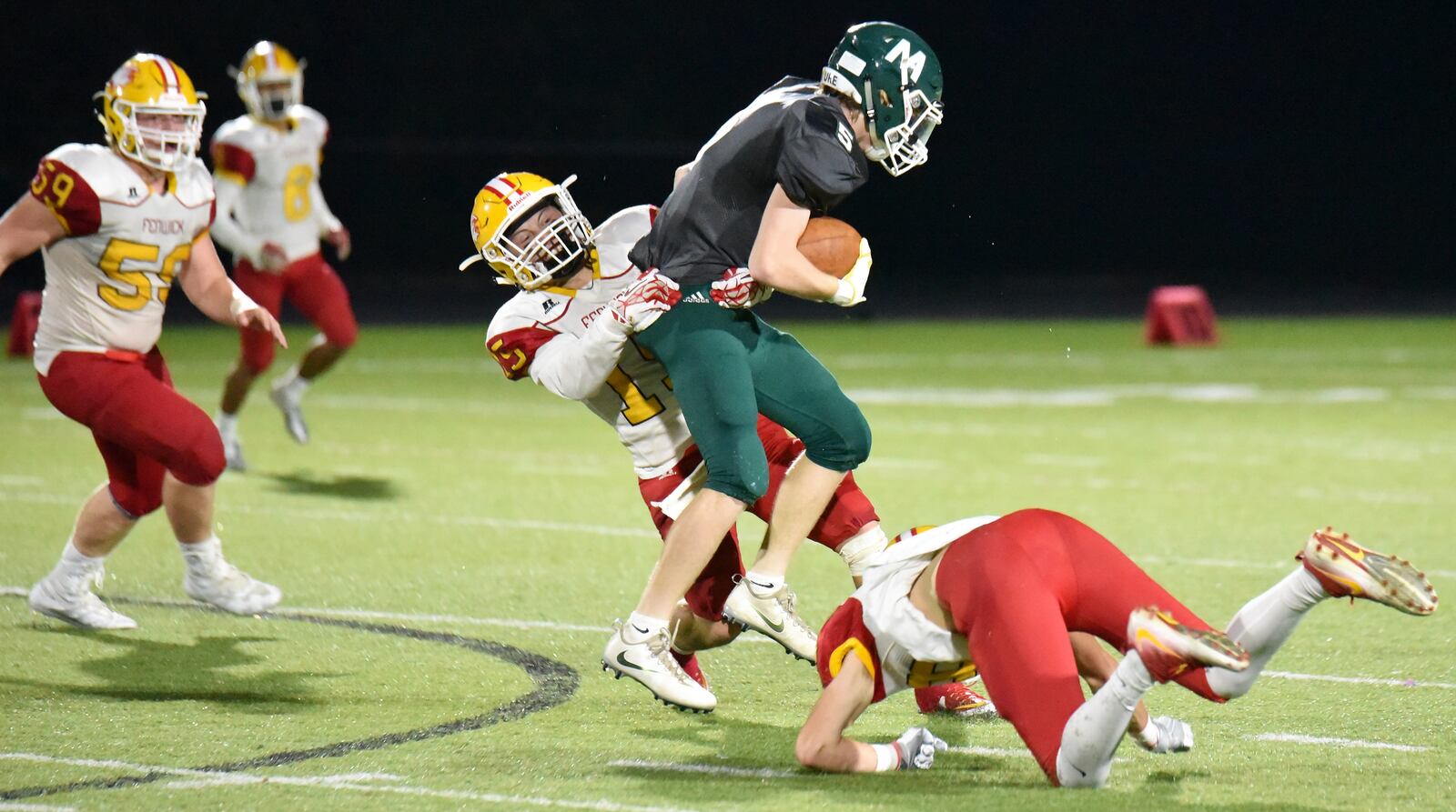 Fenwick’s Henry Nenni (15) and Nate Green (18) tackle Andrew Clark (5) of McNicholas during Friday night’s game at Penn Station Stadium in Cincinnati. Fenwick recorded a 57-26 victory. CONTRIBUTED PHOTO BY ANGIE MOHRHAUS
