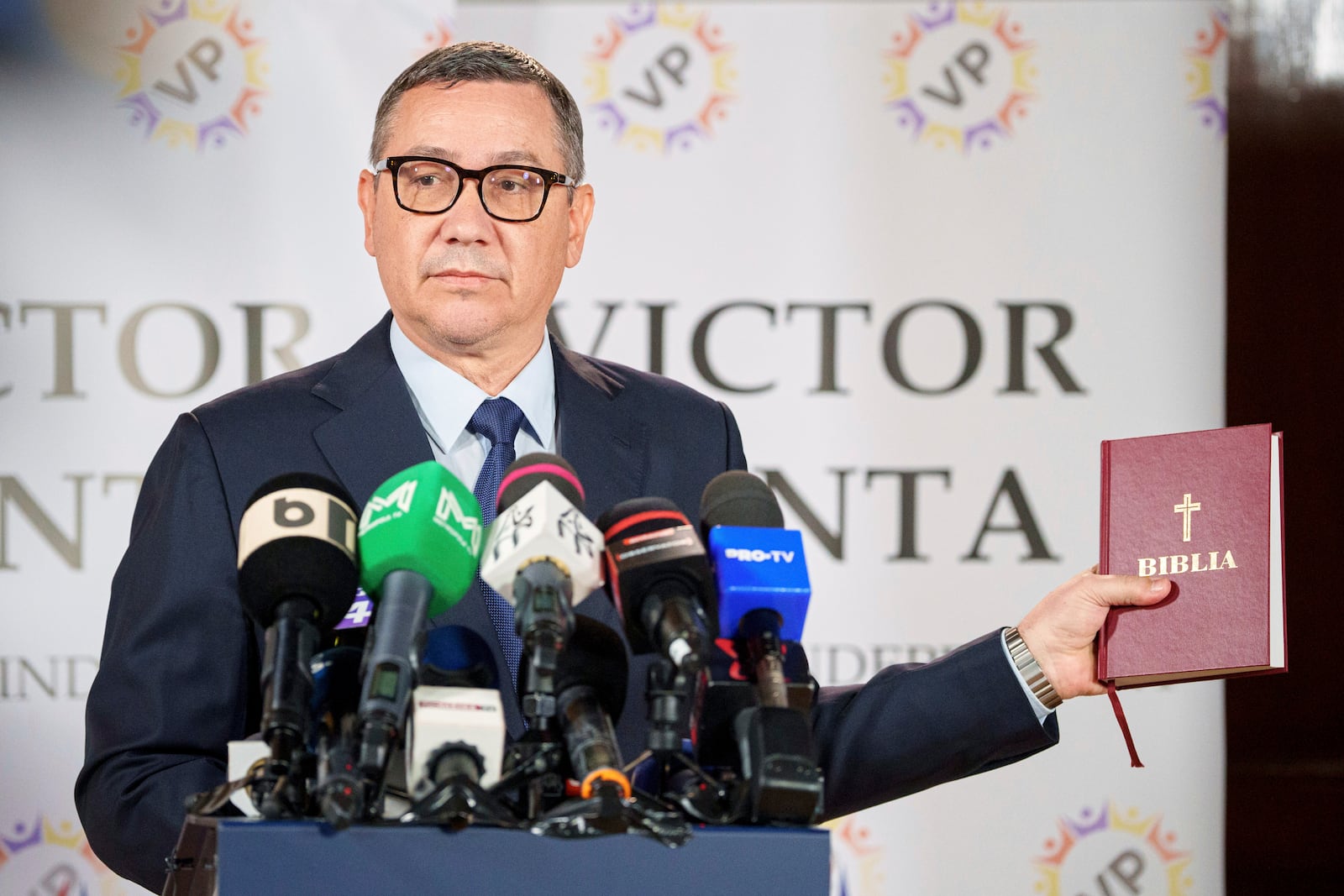 Presidential candidate Victor Ponta holds a bible during a press conference in Bucharest, Romania, Friday, May 2, 2025. (AP Photo/Andreea Alexandru)