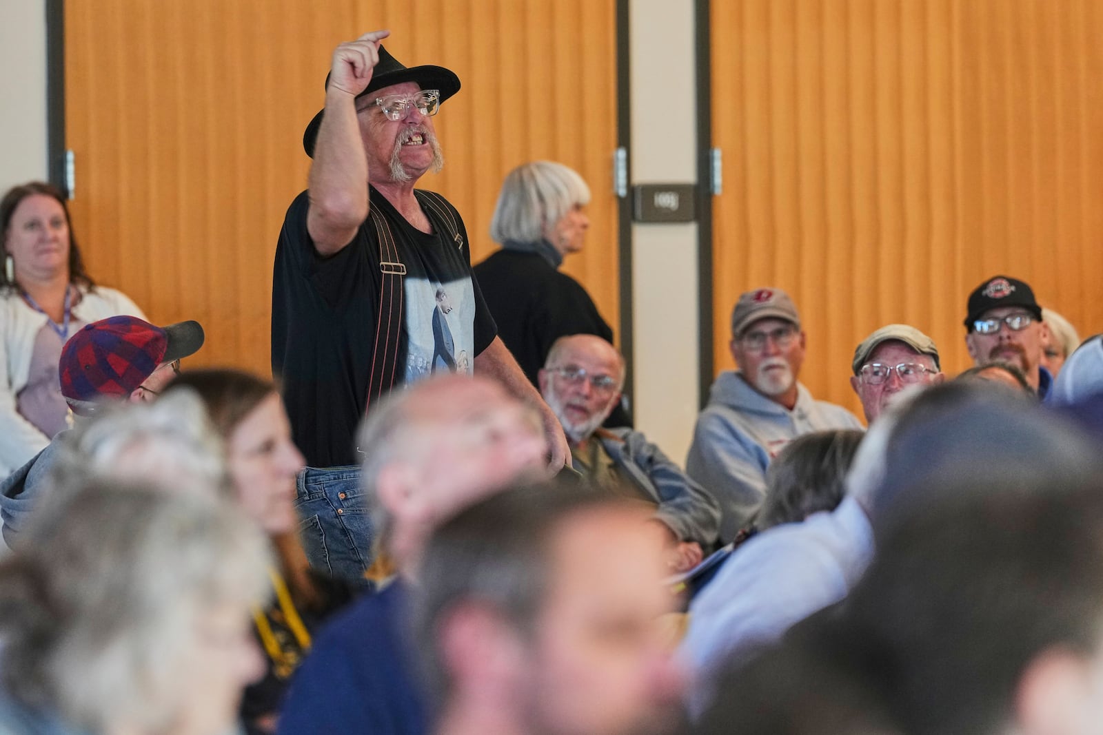 An attendee stands and shouts towards the stage during a town hall event with Rep. Marie Gluesenkamp Perez, D-Wash., at Centralia College, Tuesday, April 22, 2025, in Centralia, Wash. (AP Photo/Lindsey Wasson)
