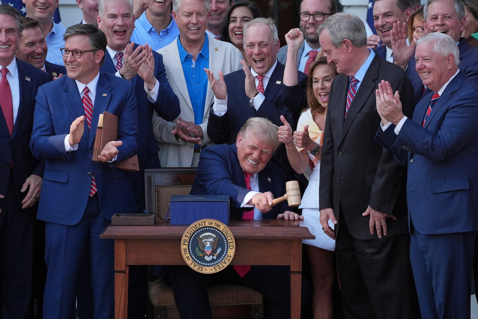 President Donald Trump bangs a gavel presented to him by House Speaker Mike Johnson of La., after he signed his signature bill of tax breaks and spending cuts at the White House, Friday, July 4, 2025, in Washington. (AP Photo/Evan Vucci)