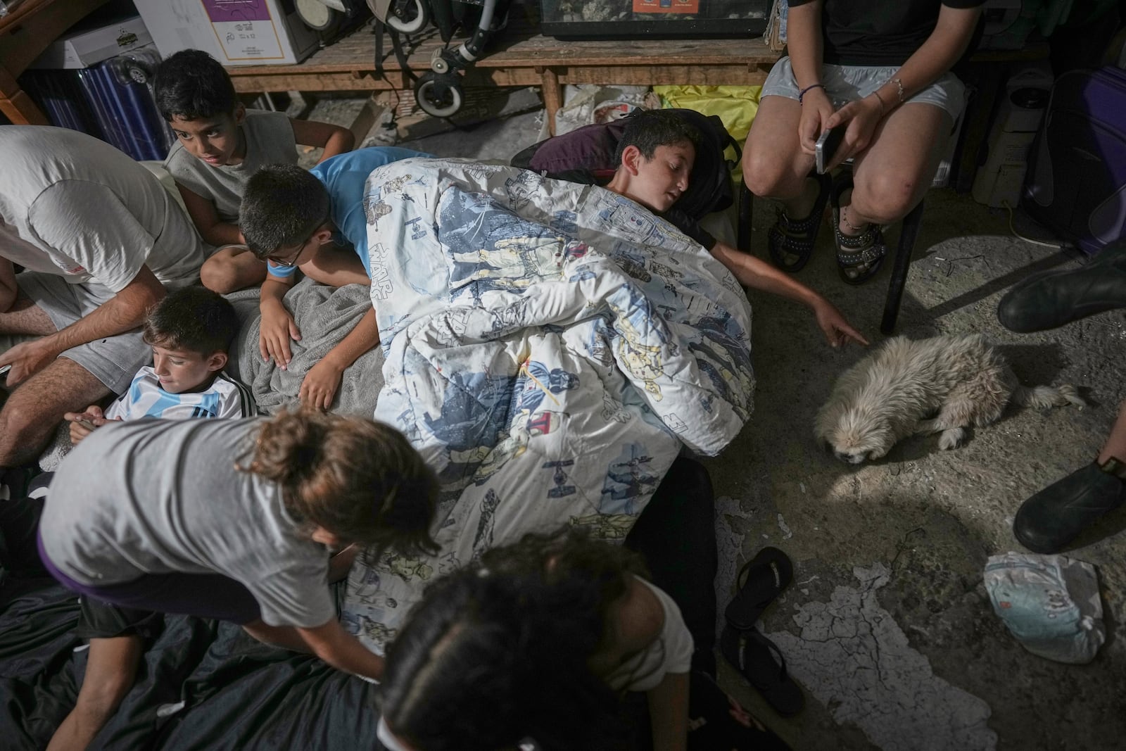 Israeli children take shelter during air raid sirens warning of incoming strikes by Iran, in Bnei Brak, near Tel Aviv, Israel, Tuesday, June 17, 2025. (AP Photo/Oded Balilty)