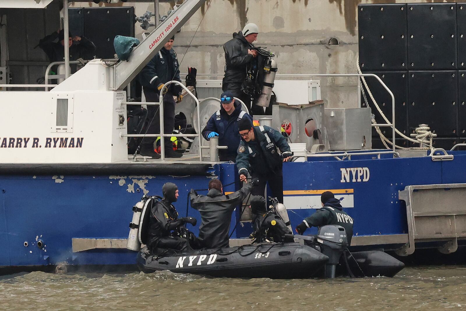 A New York Police Department scuba team exits the water, Friday, April 11, 2025, after diving at the site where a sightseeing helicopter crashed a day earlier into the Hudson River in Jersey City, N.J. (AP Photo/Yuki Iwamura)
