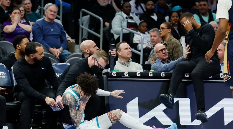 Charlotte Hornets guard LaMelo Ball holds his head after colliding with head coach Charles Lee during the first half of an NBA basketball game against the New Orleans Pelicans, in Charlotte, N.C., Monday, Feb. 2, 2026. (AP Photo/Nell Redmond)