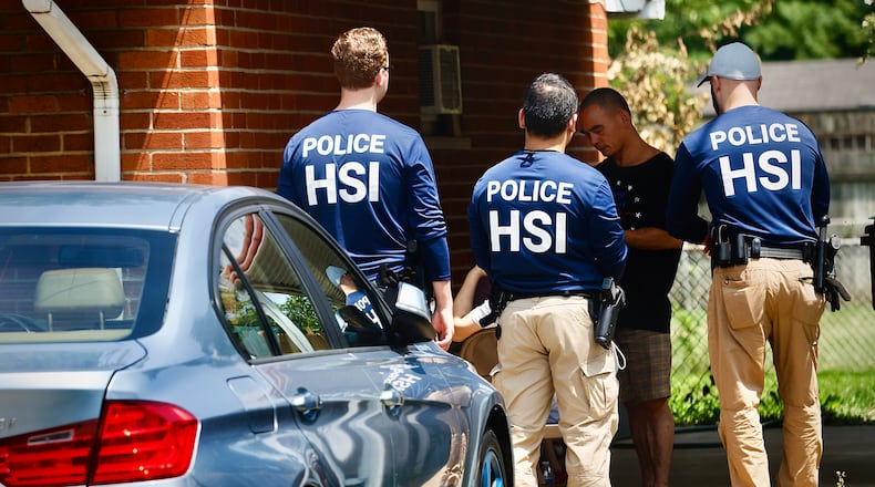 Homeland Security police talk to several people outside a home Friday, July 26, 2024 on Hoyle Pl. in Kettering. MARSHALL GORBY \STAFF