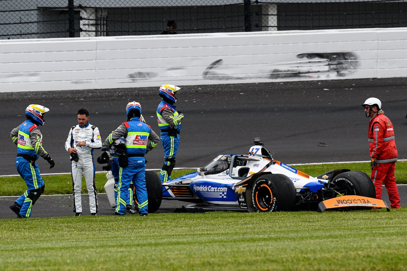 Kyle Larson, second from left, is checked after he hit the wall in the second turn during Indianapolis 500 auto race at Indianapolis Motor Speedway in Indianapolis, Sunday, May 25, 2025. (AP Photo/Jamie Gallagher)