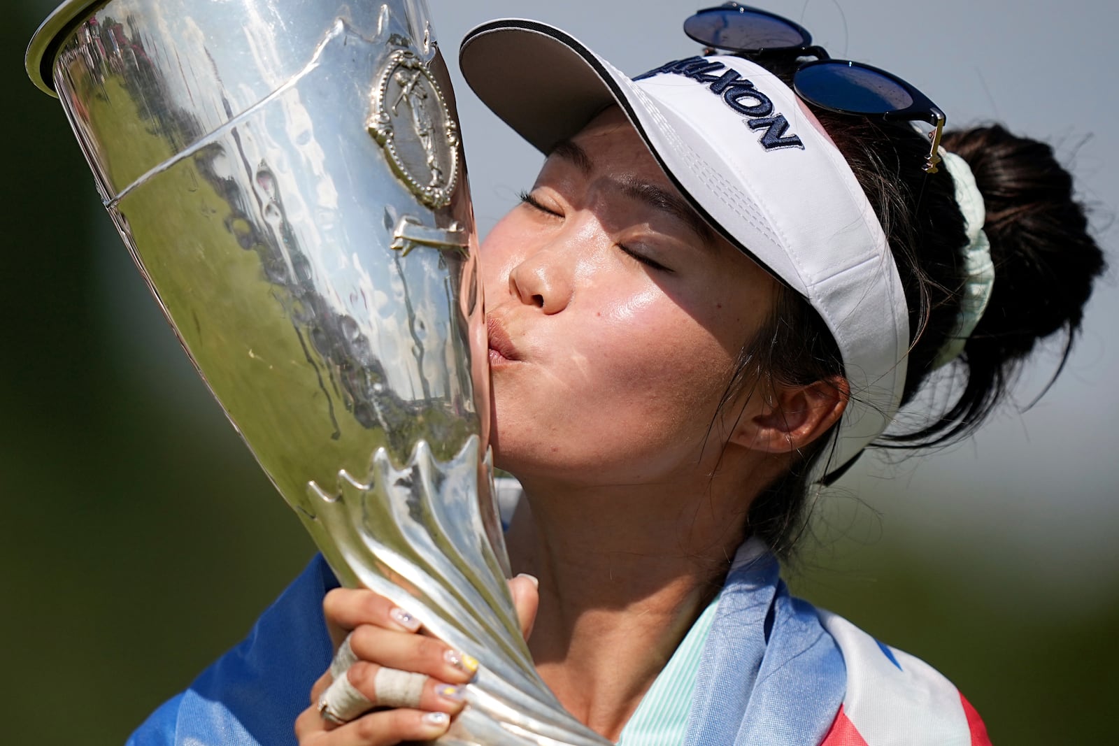 Grace Kim, of Australia, kisses her trophy after winning the Evian Championship women's golf tournament, in Evian, eastern France, Sunday, July 13, 2025. (AP Photo/Laurent Cipriani)