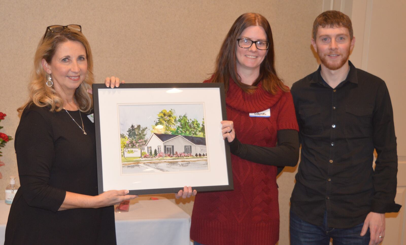 Gloyeske Family Chiropractic was honored as a Business of the Year by the Chamber of Commerce. Accepting the watercolor painting of the business were Mandy Gloyeske and Brad Gloyeske. Presenting the award was Chamber President Kelli Riggs, left. CONTRIBUTED/BOB RATTERMAN