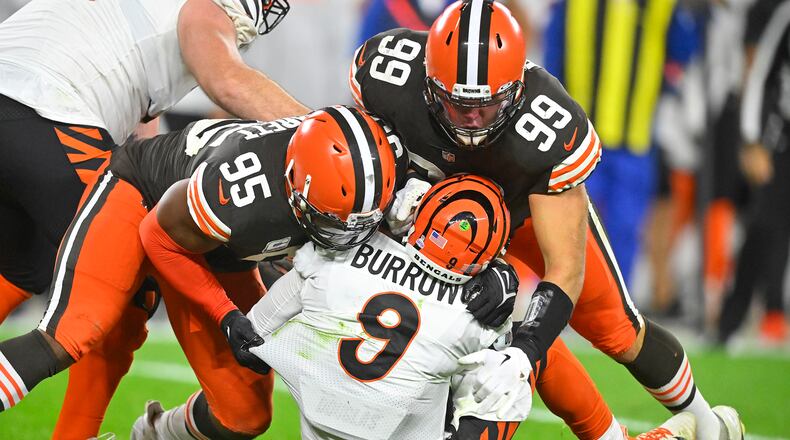 Cincinnati Bengals quarterback Joe Burrow (9) is sacked by Cleveland Browns defensive end Myles Garrett (95) and Taven Bryan (99) during the second half of an NFL football game in Cleveland, Monday, Oct. 31, 2022. (AP Photo/David Richard)